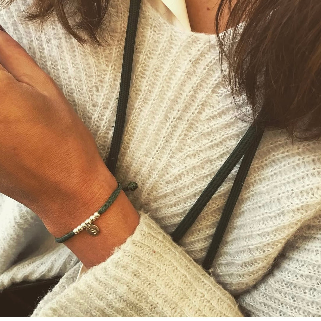 Pulsera elástica con placa mini de plata.