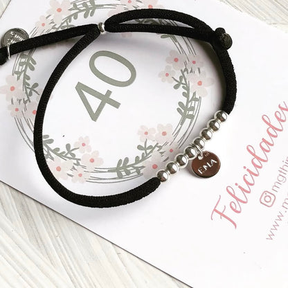 Pulsera elástica con placa mini de plata.