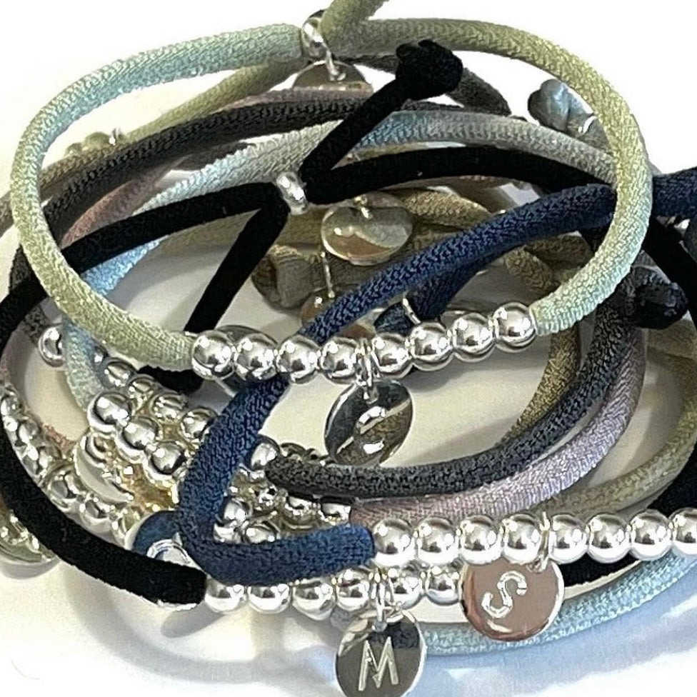 Pulsera elástica con placa mini de plata.