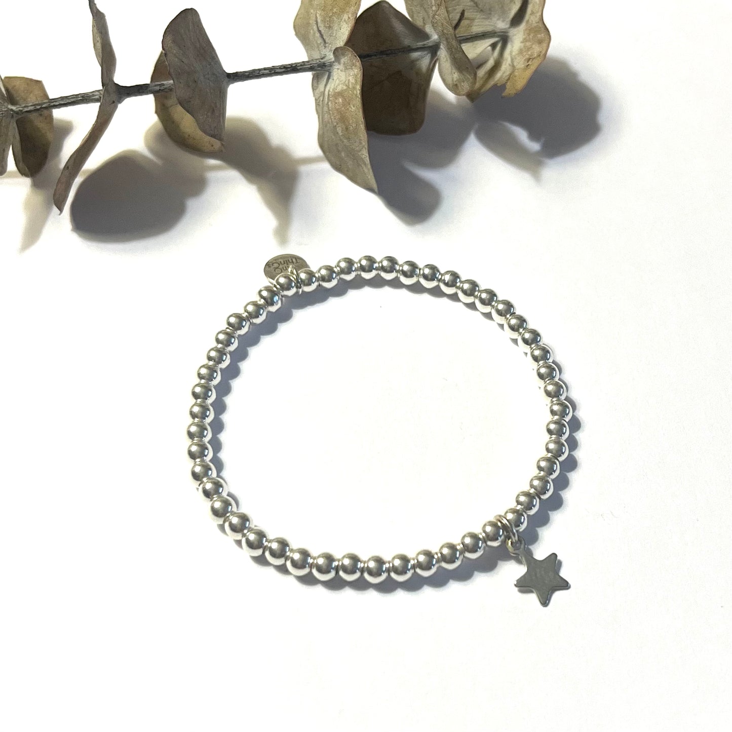 Pulsera elástica de bolitas de plata con estrella mini.