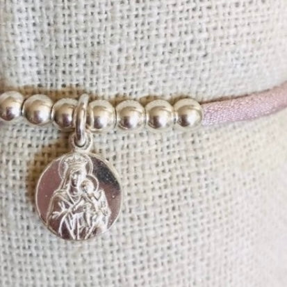 Pulsera con cinta elástica de seda con medalla religiosa.