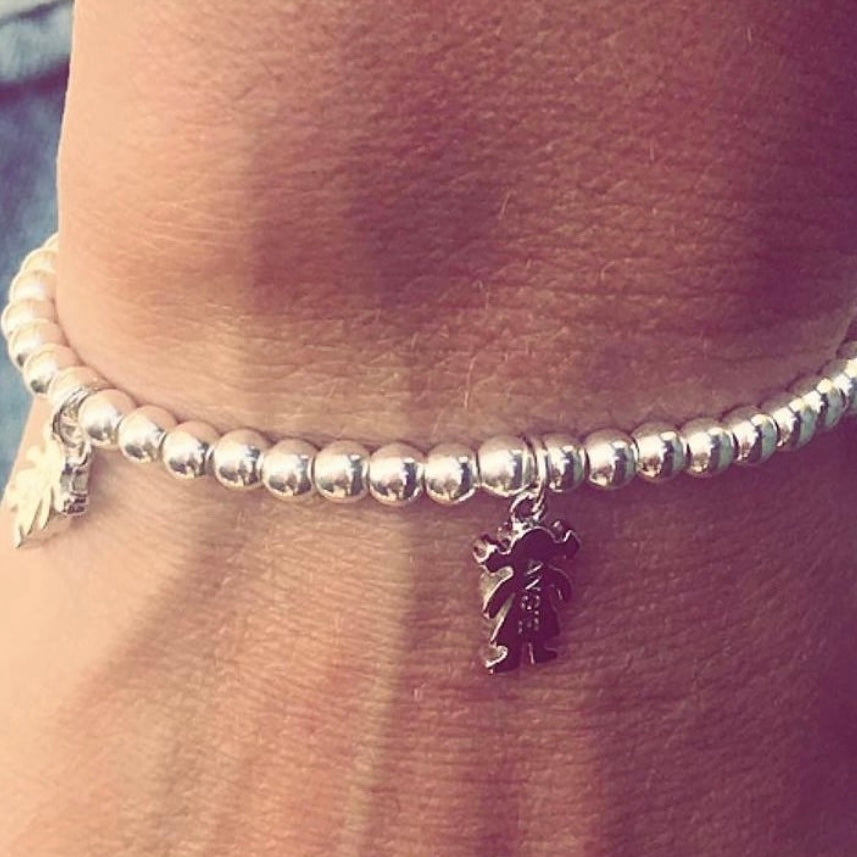 Pulsera personalizada con bolitas de plata y charm de niño o niña.
