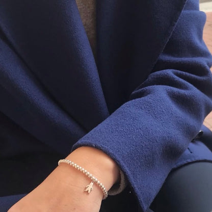 Pulsera personalizada con bolitas de plata y charm de niño o niña.