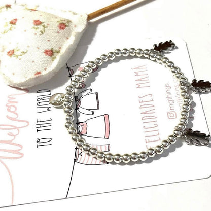 Pulsera personalizada con bolitas de plata y charm de niño o niña.