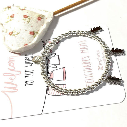 Pulsera personalizada con bolitas de plata y charm de niño o niña.