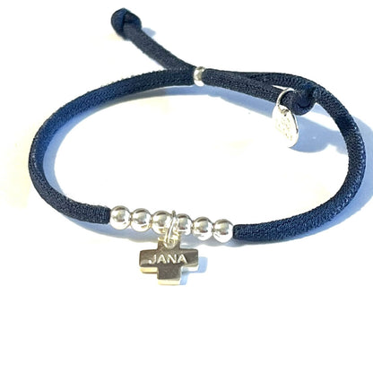 Pulsera con cinta elástica y cruz personalizada.