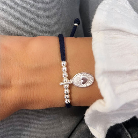 Pulsera elástica con bolitas y medalla Detente de plata.