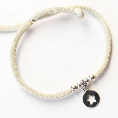 Pulsera elástica de plata con estrella colgante.