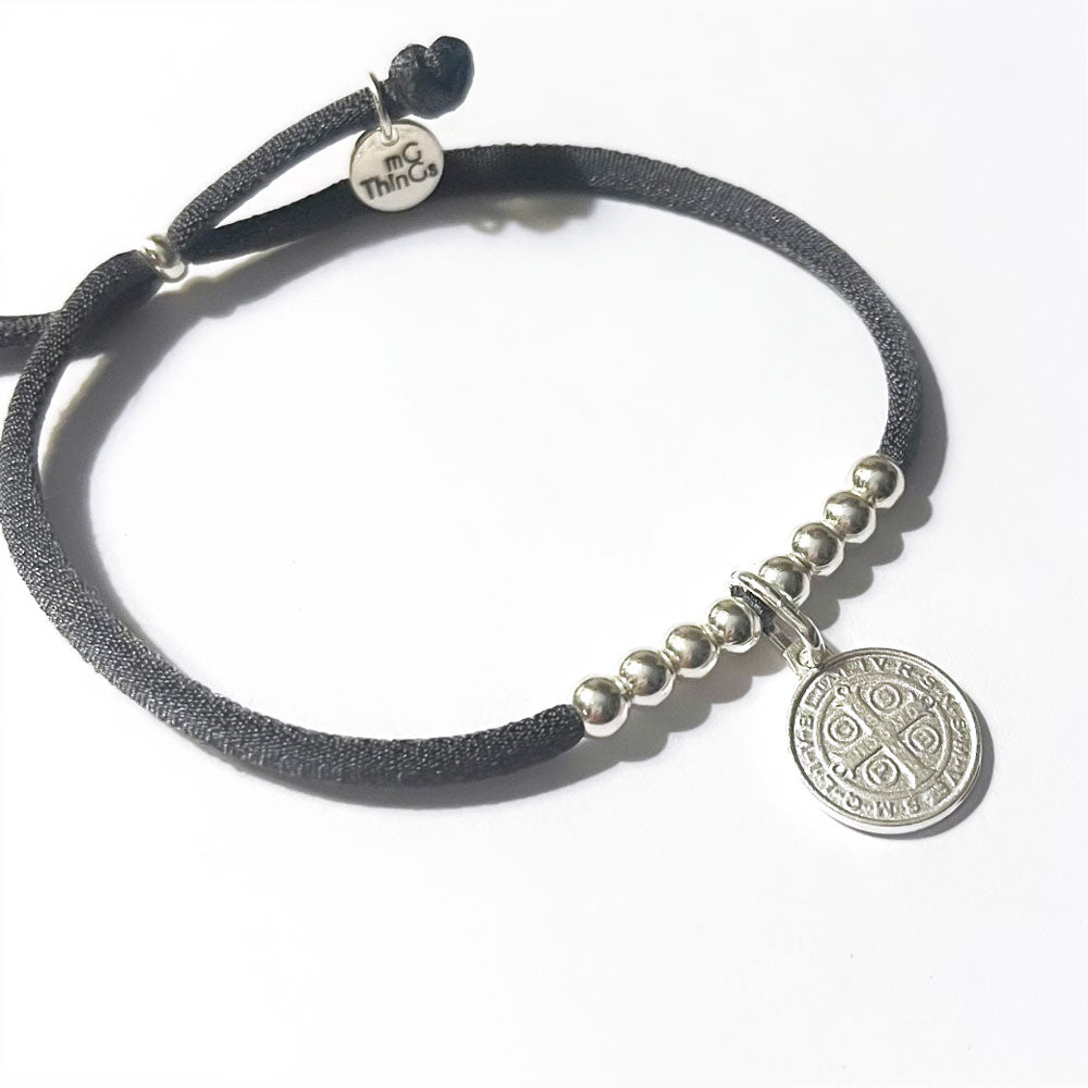 Pulsera elástica de plata con medalla San Benito colgante.