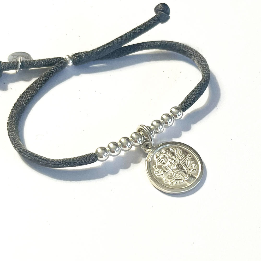 Pulsera con cinta elástica de seda con medalla religiosa.